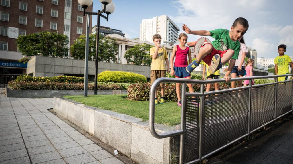 A child vaults over a rail outdoors